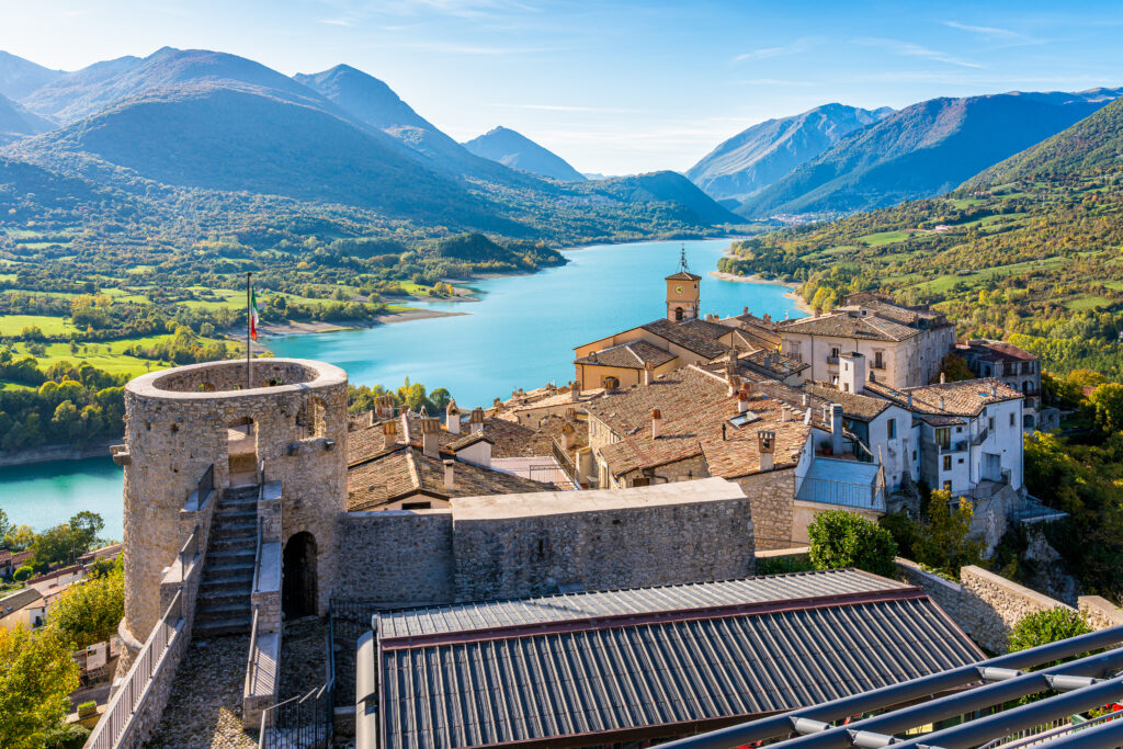 Italy town bordering lake surrounded by green trees