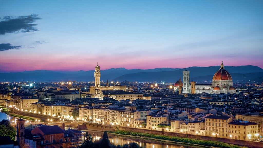 Florence city at night illuminated against pink sky