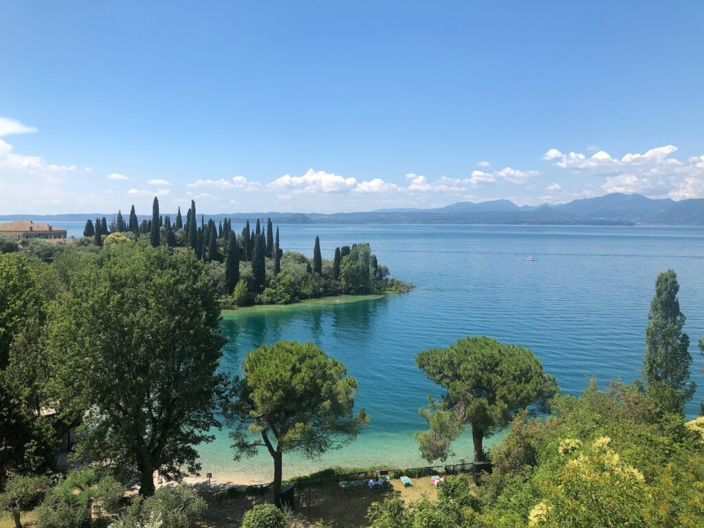 Lake Garda waters lined by trees and small beach