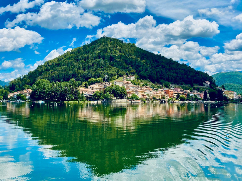 Island in lake with town at lakeside edge overlooking blue lake