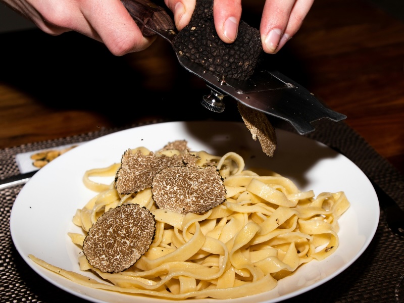 Plate of pasta with truffle being shaved on top