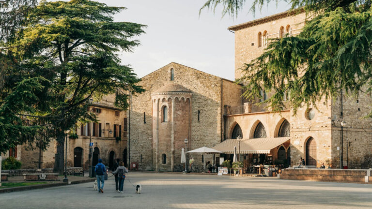 light stone buildings in Italian town square with trees