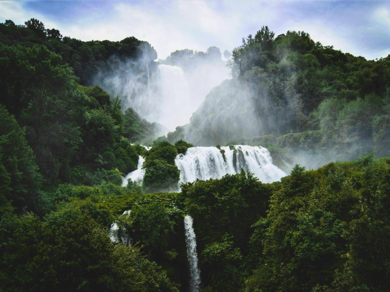 Waterfalls running down green countryside mountains