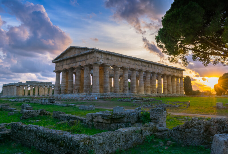 Beautiful sunset in the archaeological site of Paestum with the temples of Neptune and Hera in the background - Campania, Italy