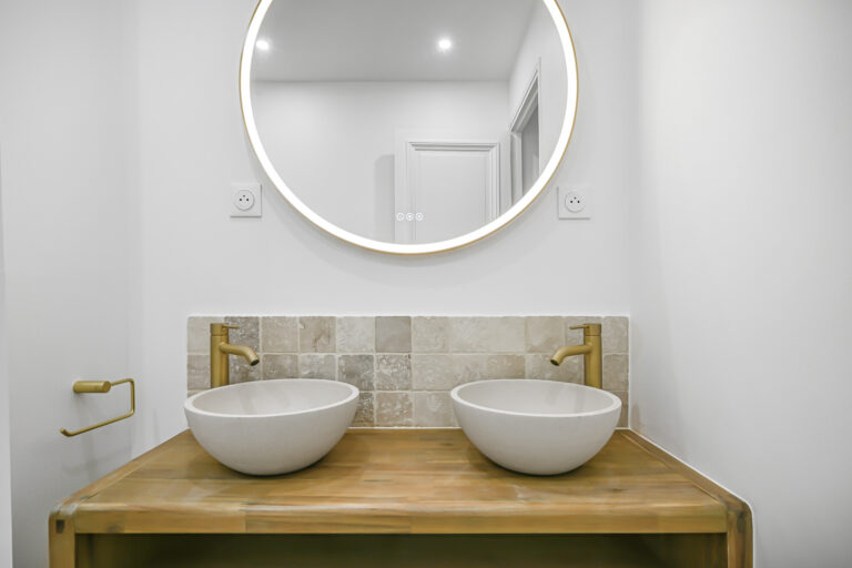 Wood vanity unit with 2 sinks and round mirror