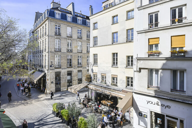 Exterior of a Parisian building with cafe below