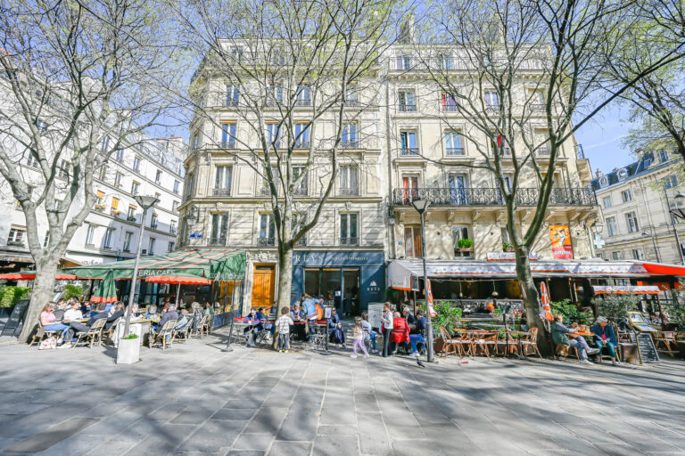 Maison Rivoli Paris building with cafes below and trees outside