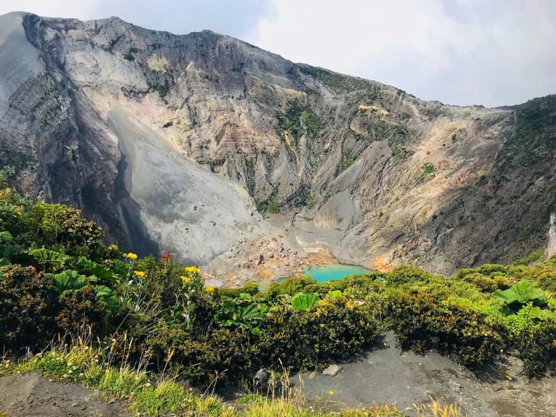 blue volcano crater with flowers and greenery at top